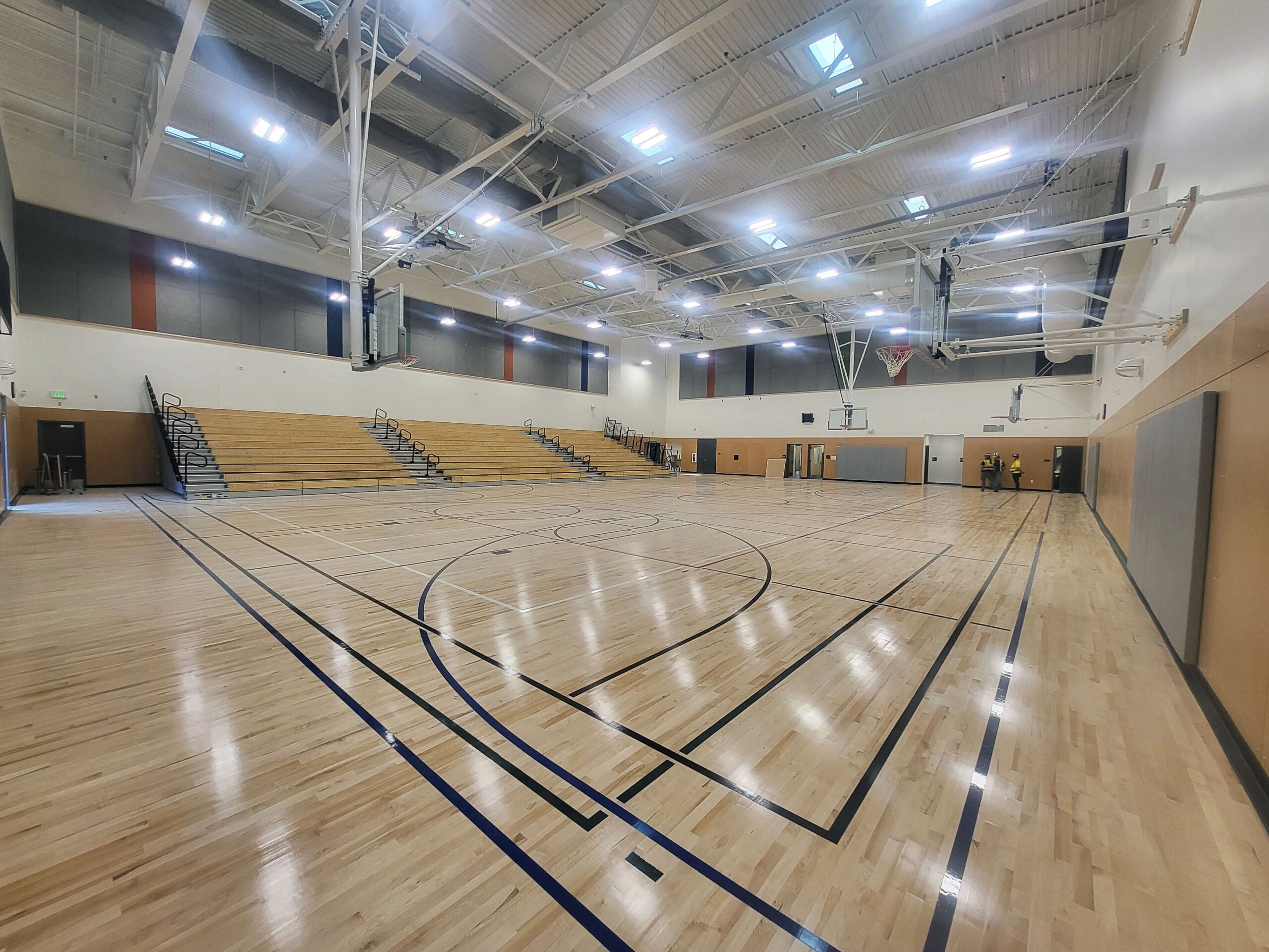 a gymnasium with bleachers on one wall