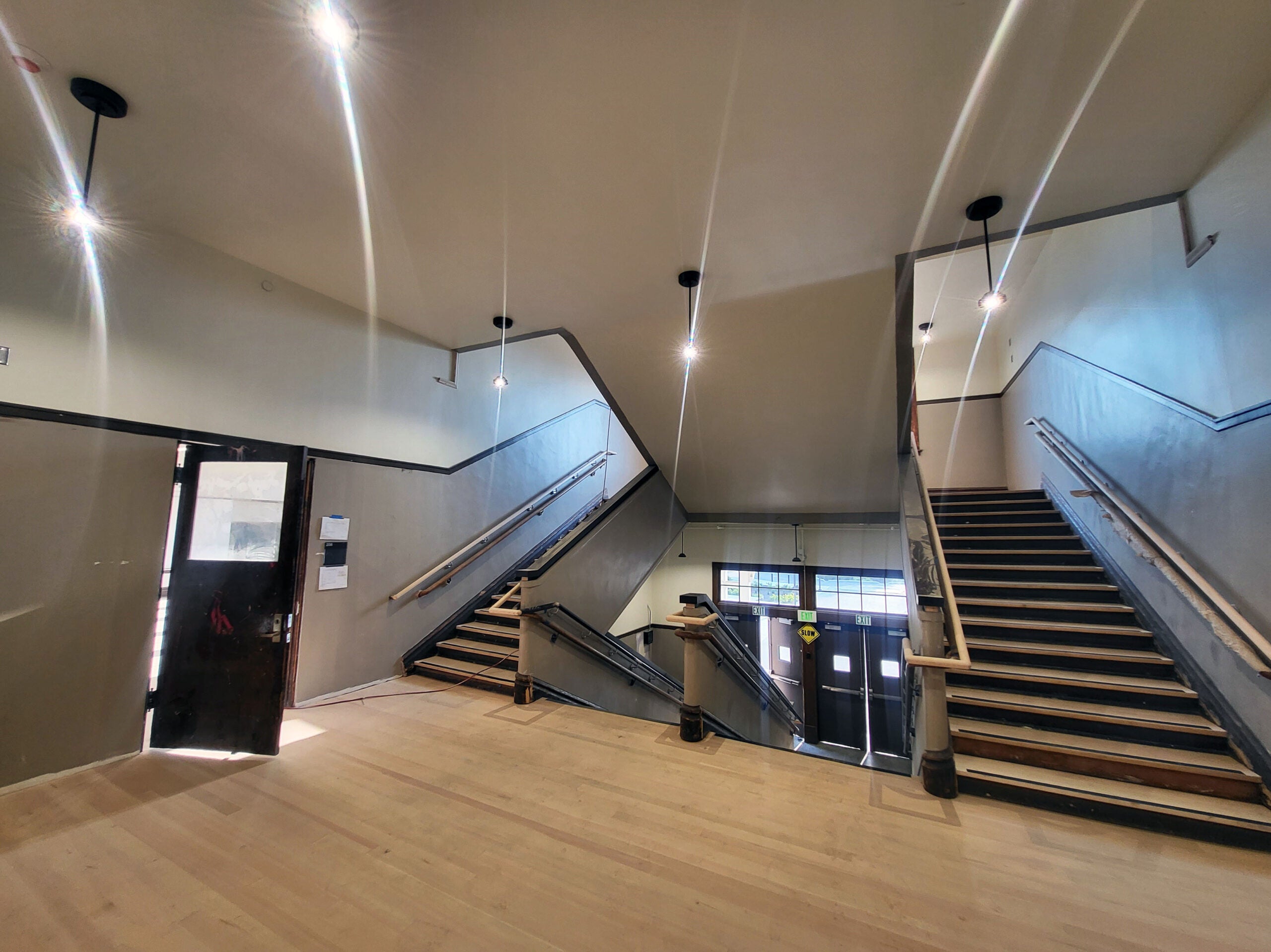 a landing with an open door to one side. stairs lead up to the landing and from the landing up to another floor