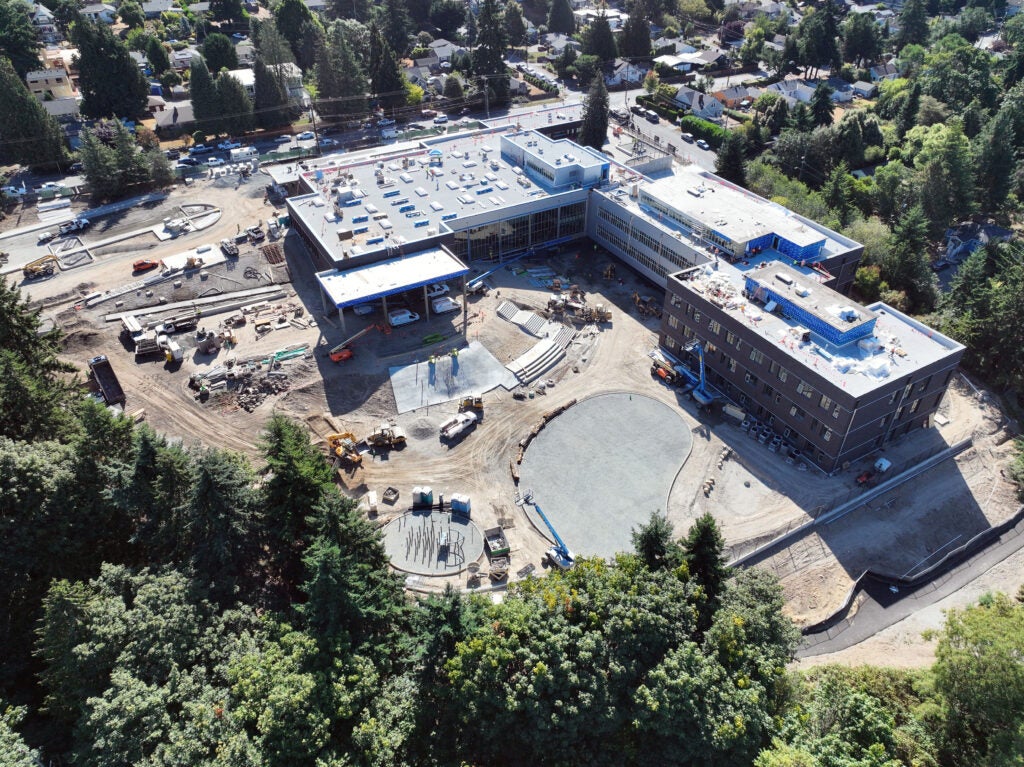 aerial view of an L shaped building with construction work happening in the area between them