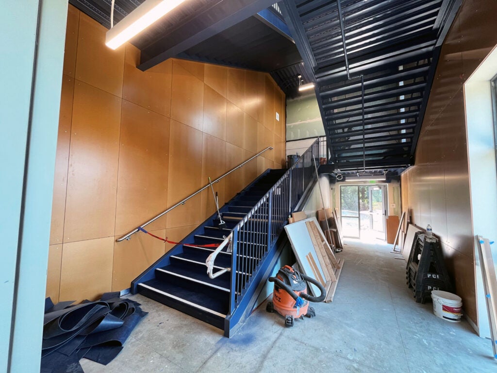 a stairway leads up with wood walls next to it