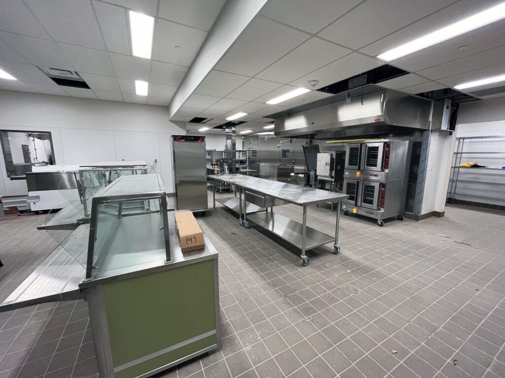a large room with tile floors and metal kitchen equipment