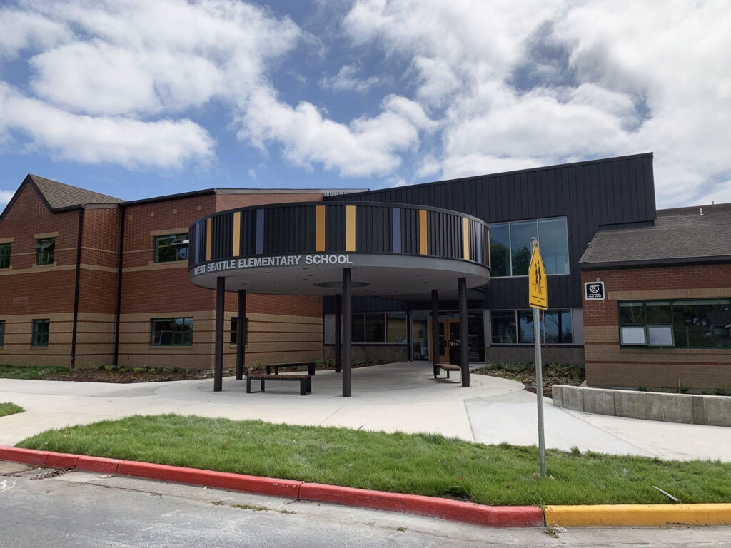 a circular canopy says West Seattle Elementary School and is in front of an entry door