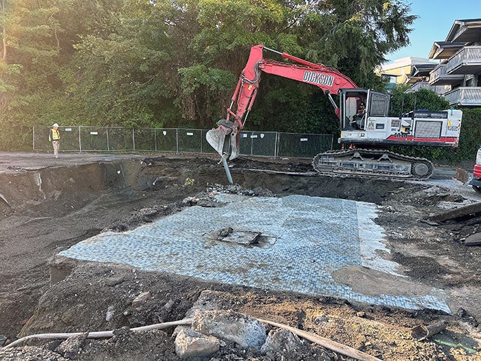 a back hoe demolishing a building floor