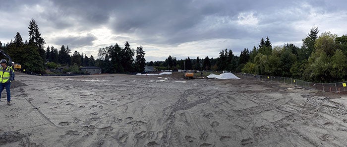 a dirt field with sky and clouds