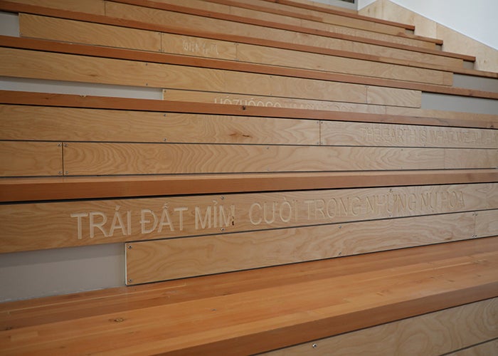a wooden stair designed for sitting has words in several languages on the risers