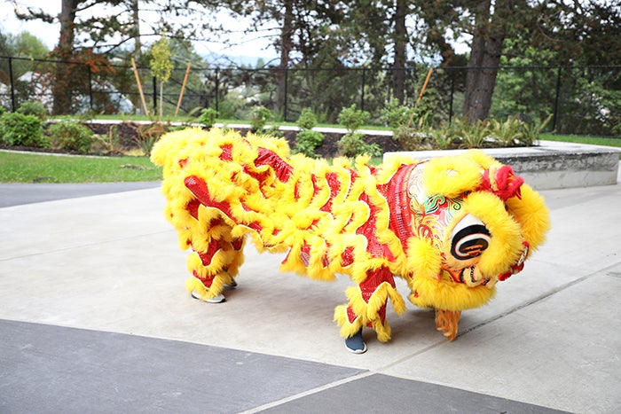 two people in a yellow lion dancer costume