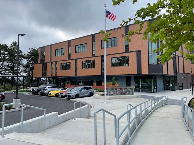 A two story brick building has a walkway leading toward it