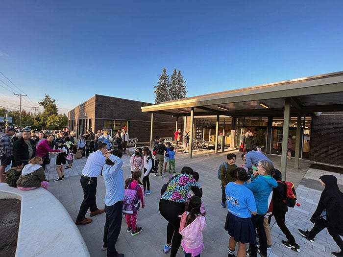 a group of adults and children outside of a building