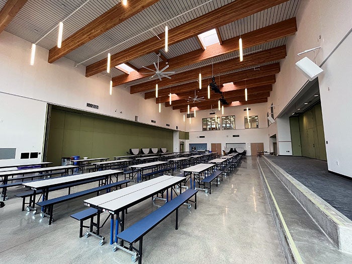 a lunchroom with tables and ceiling fans