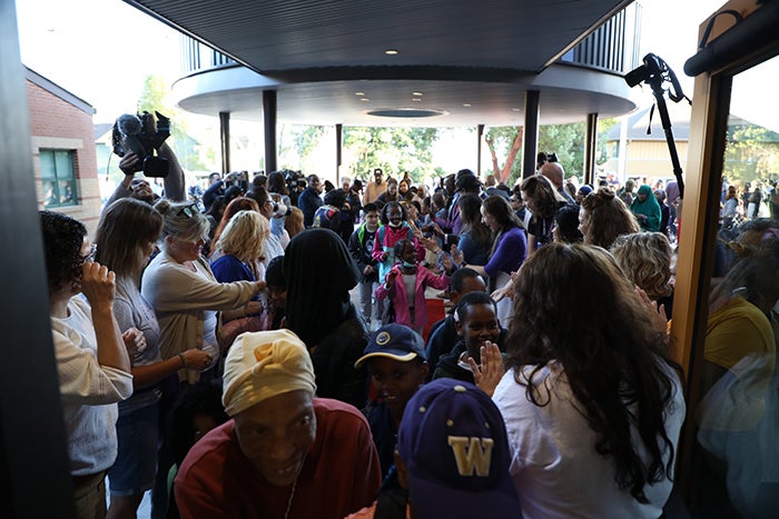a crowd of people includes children and adults and are moving toward the camera