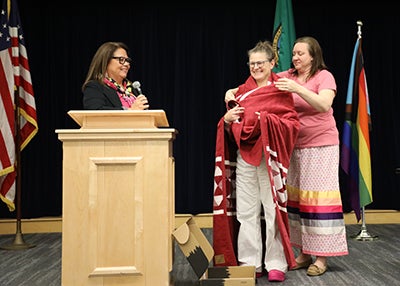 Staff present Director Hampson with a blanket during the ceremony