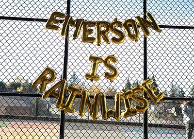 A balloon garland on a school fence that reads Emerson is Rainwise
