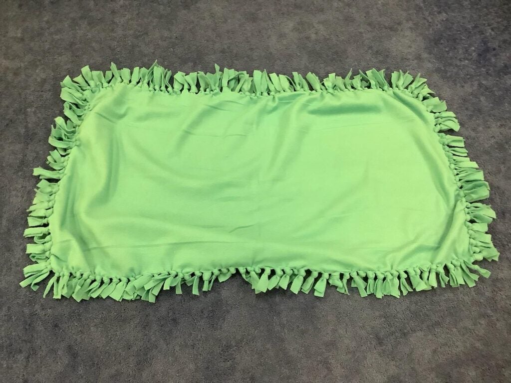 One lime green tie blanket, unfolded