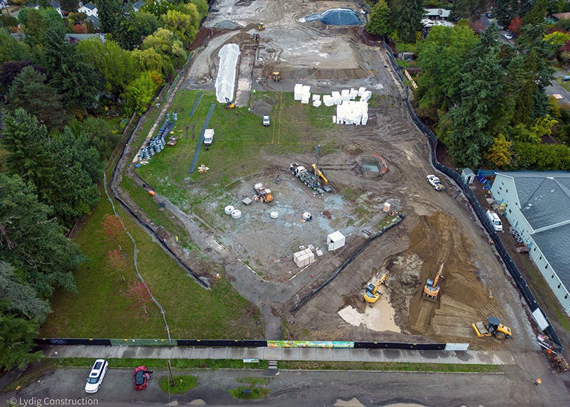 aerial view of a large construction site that has mud, grass, and equipment