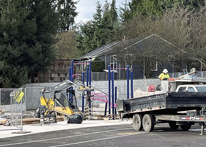 people installing a play structure with equipment