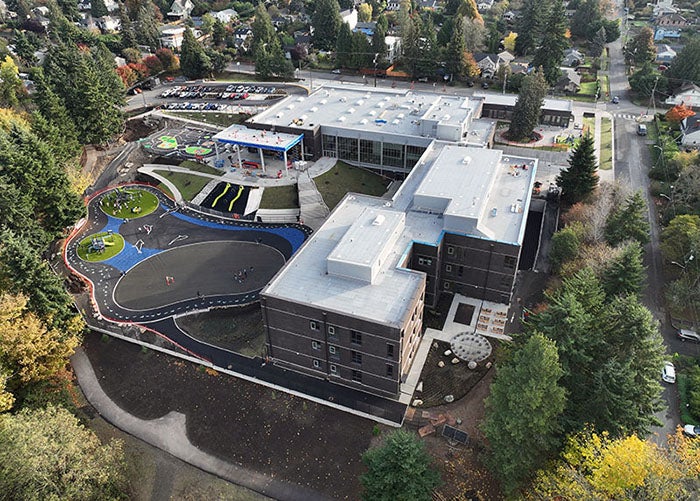 aerial view of a large four story building with a play area that has playground equipment