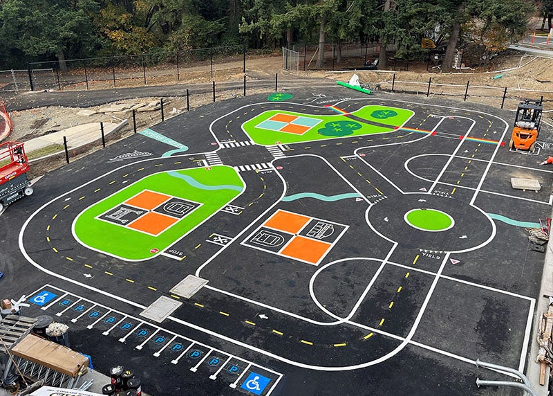 a paved area has a play area road and parking painted on it