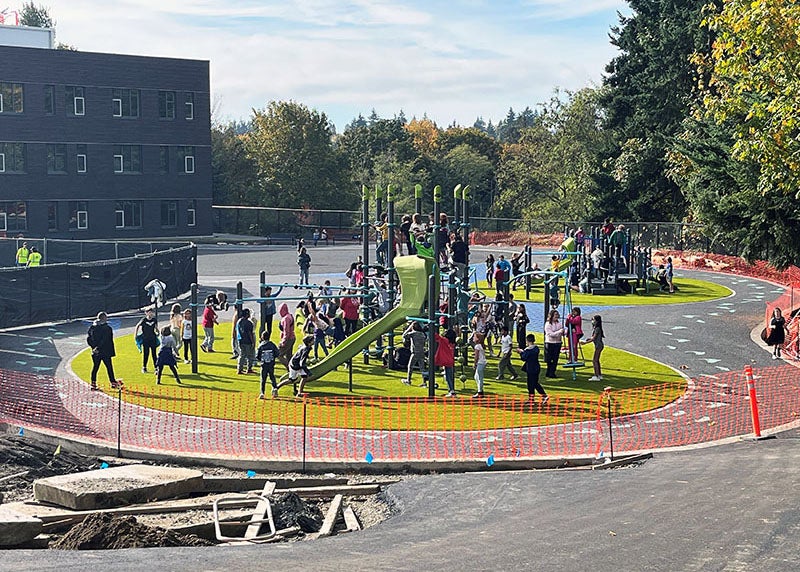 students are using playground structures that have temporary orange construction fencing around them