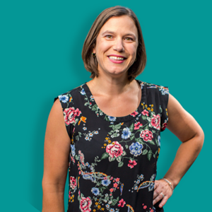 Julie Gatti of Franklin smiles for a photo on a teal background