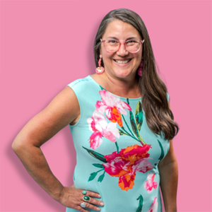 Michele Amato of Eckstein smiles for a photo on a pink background