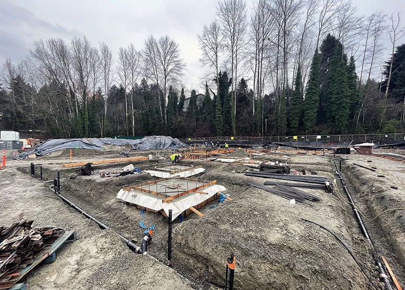 a dirt construction site with trenches and construction materials