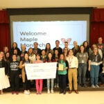 Group photo of all Maple Elementary staff holding School of Distinction Award