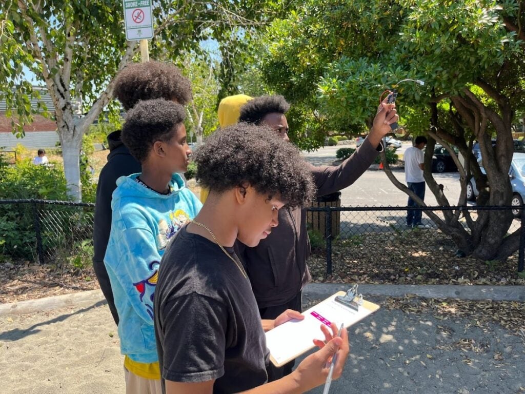 Students conducting experiment using micro bit outside of school