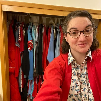 Chief Sealth teacher in front of her school spirit closet with red and blue clothing