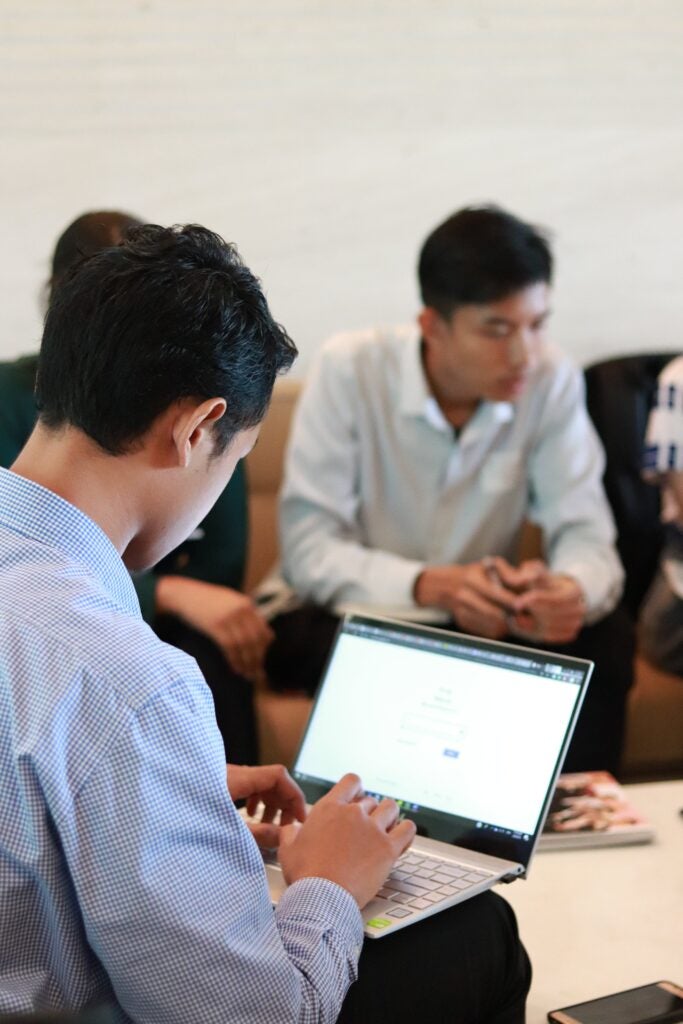 Students around table, one on laptop