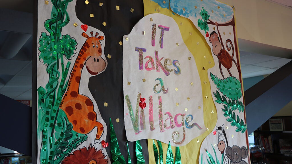 Poster with the words "It Takes a Village" on it.