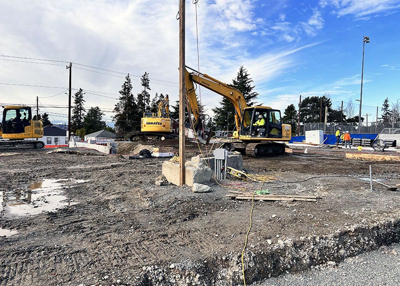 a backhoe moves soil at a construction site