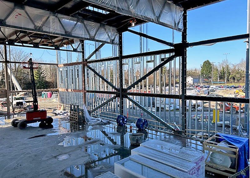 looking out through structural steel framing with metal studs on a building under construction