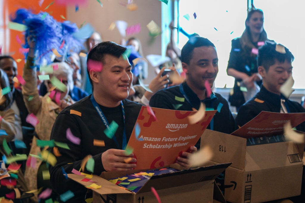 Confetti falls on students as they receive their scholarships from Amazon.