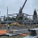 a crane is installing steel framing for a large building