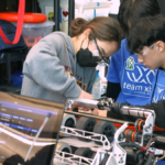Xbot Robotics team works on robot at competition.