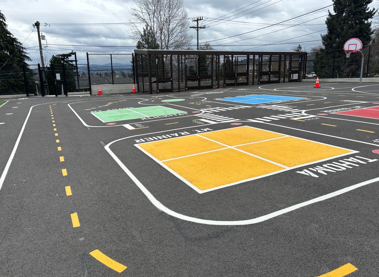 Mini streescape wraps around four square courts on blacktop.
