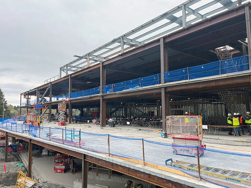 part of a large building under construction with the second floor sticking out much further than the framed building and 3rd floor