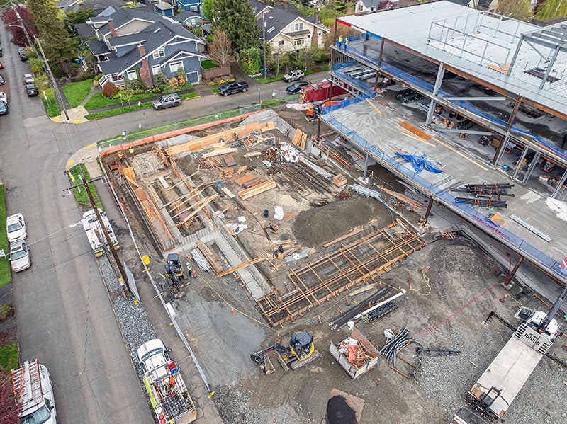 concrete footings and wood frames next to a building under construction