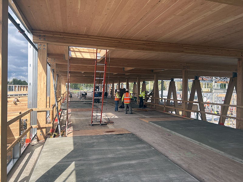a partially framed building has a wood ceiling resting on wood beams and posts