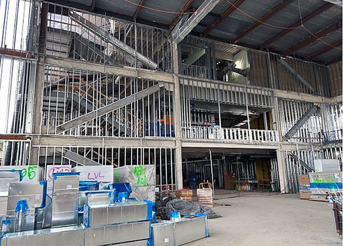 Interior of a building under construction with metal framing. metal ductwork pieces are stacked on the floor
