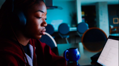 Student looking at a computer with blue background