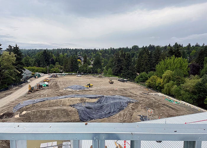 a large dirt lot with some mounds and construction grading machines