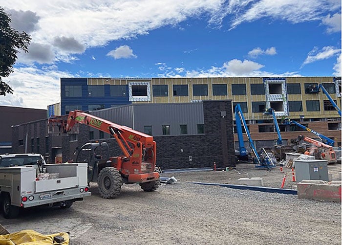 a four story building with lots of window openings is under construction