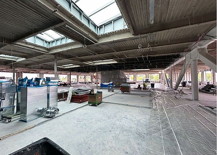 a celing has skylights framed in above a concrete floor with construction materials