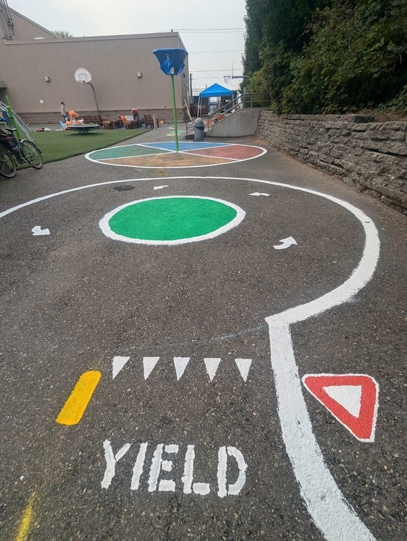 Miniature street painted with yield and roundabout.