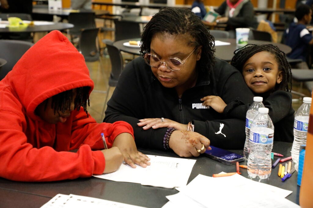 parent and children working at a table together