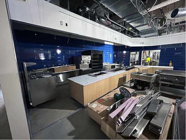 a large room with bright blue tile walls and metal kitchen equipment