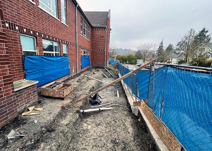 a long narrow hole next to a brick building