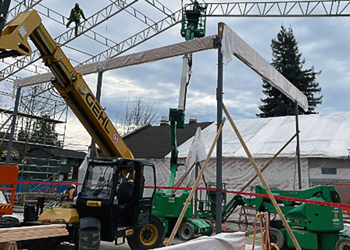 a building under construction with beams being lifted into place