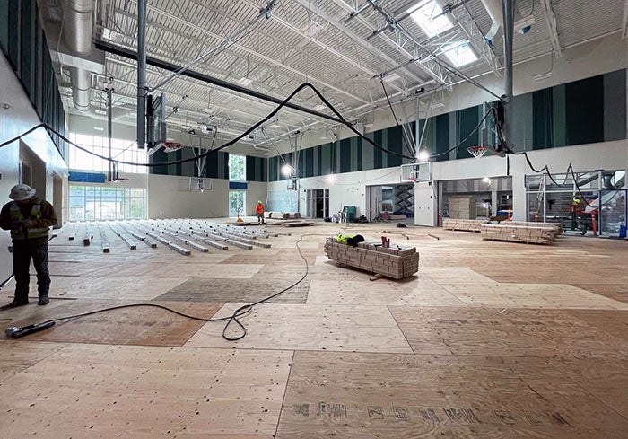 a partially finished gymnasium with flooring being installed